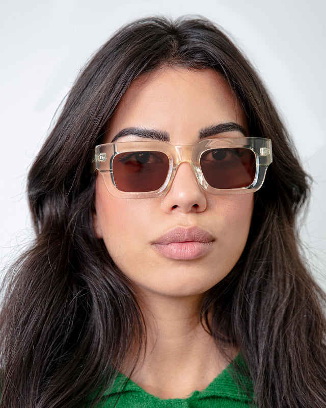 Brunette model in a green polo shirt wearing Lewis Sunglasses Champagne with Brown Flat