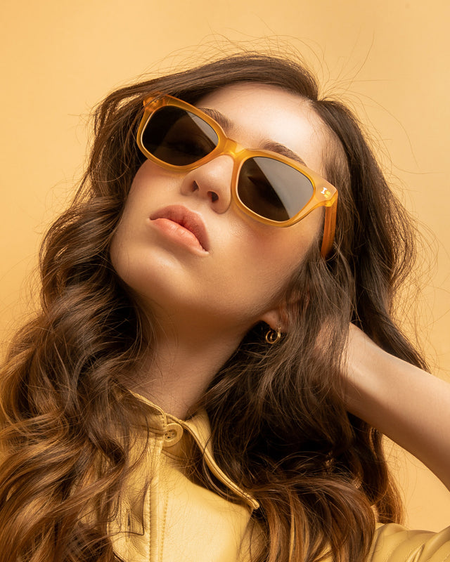 Brunette model with wavy hair wearing Melrose Sunglasses Honey Gold with Olive Flat