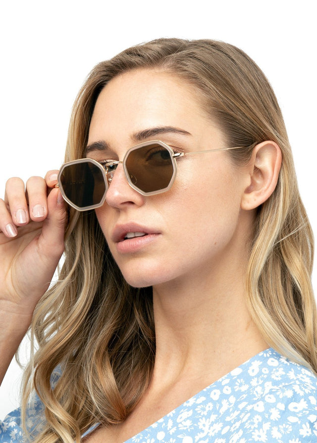 Blonde model with wavy hair wearing Dylan Tate Sunglasses Citrine Gold with Grey Flat