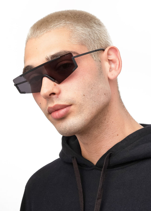 Angled pose of model with blonde buzzcut wearing Morph Sunglasses Matte Black with Grey