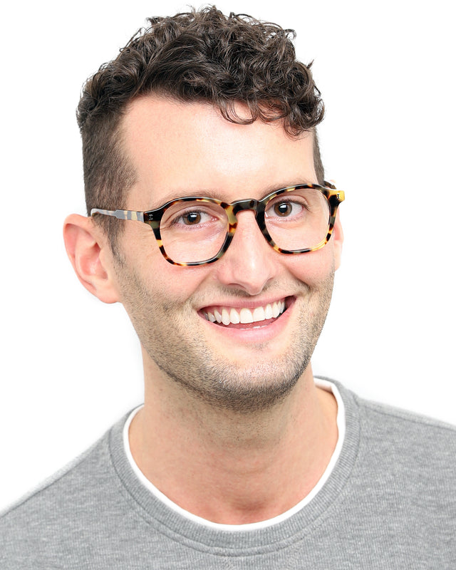 Model with brown curly hair wearing Nash Optical Tortoise Optical