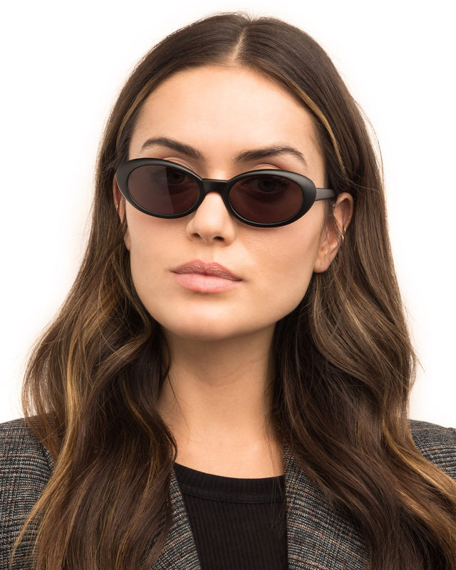 Brunette model with wavy hair wearing Seattle Sunglasses Matte Black with Grey Flat Lenses