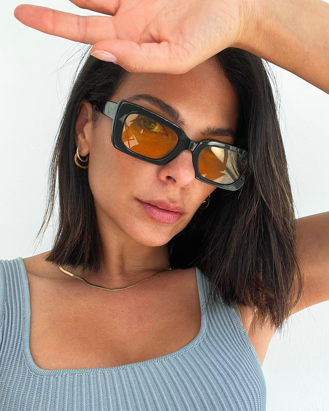 Brunette model with shoulder-length, straight hair wearing Wilson Sunglasses Black with Honey Flat See Through