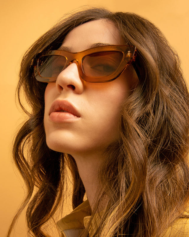 Brunette model with curly hair wearing Donna Sunglasses Cider with Brown Gradient